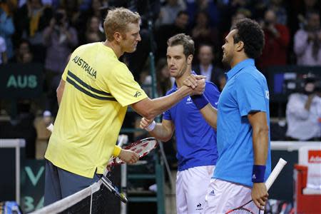 French player Jo-Wilfried Tsonga (R) and compatriot Richard Gasquet is congratulated by Chris Guccione (L) of Australia after their Davis Cup world group first round tennis doubles match in Mouilleron-Le-Captif, Western France, February 1, 2014. REUTERS/Stephane Mahe