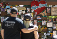 People visit a memorial garden for victims of a mass shooting in Las Vegas, Thursday, Oct. 3, 2019, in Las Vegas. Two years after a shooter rained gunfire on country music fans from a high-rise Las Vegas hotel, MGM Resorts International reached a settlement that could pay up to $800 million to families of the 58 people who died and hundreds of others who were injured, attorneys said Thursday. (AP Photo/John Locher)