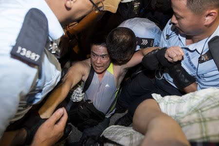 A protester is taken away by police officers after staying overnight at Hong Kong's financial Central district July 2, 2014. REUTERS/Tyrone Siu