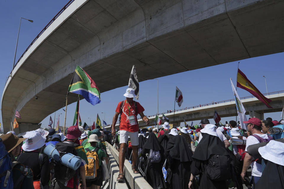 Pilgrims leave Parque Tejo in Lisbon where Pope Francis presided over a mass celebrating the 37th World Youth Day, Sunday, Aug. 6, 2023. An estimated 1.5 million young people filled the parque on Saturday for Pope Francis' World Youth Day vigil, braving scorching heat to secure a spot for the evening prayer and to camp out overnight for his final farewell Mass on Sunday morning. (AP Photo/Ana Brigida)