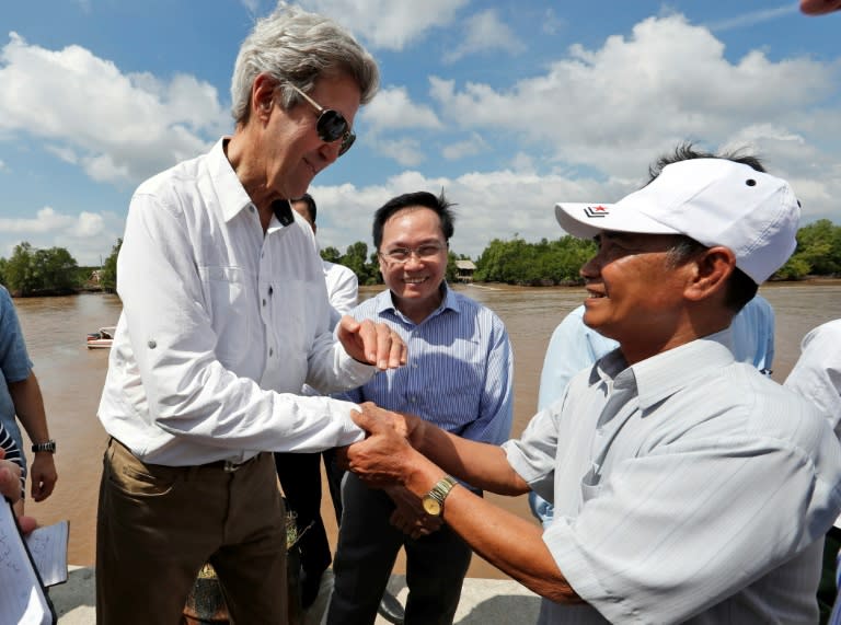 US Secretary of State John Kerry (L) shakes hands with Vo Ban Tam, 70, who was a member of the former Viet Cong guerrilla and who took part in the attack on Kerry's Swift Boat on February 28, 1969