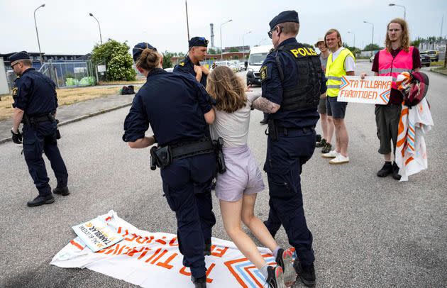 Police officers carry Swedish climate activist Greta Thunberg away from a protest June 19 that was blocking oil tankers in Malmö, Sweden.