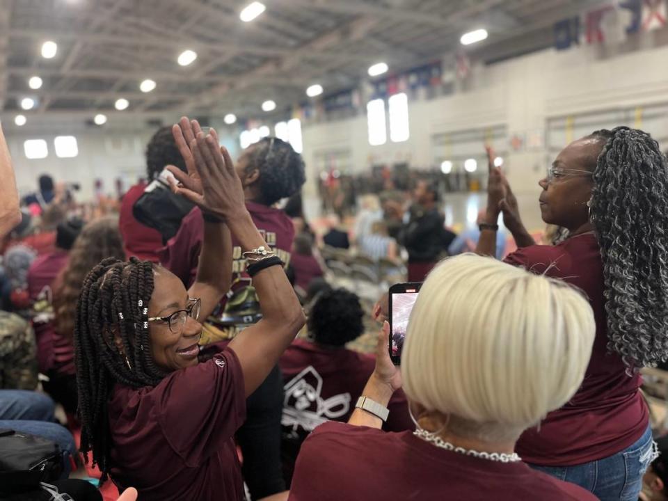 Yvonne Jones, left, and Desiree Johnson, right, cheer as the crowd gets loud during a ceremony marking the end of the Fourth Recruit Training Battalion at Parris Island, while Lisa Taylor records the event on her phone. The three friends traveled from other states to attend the ceremony.