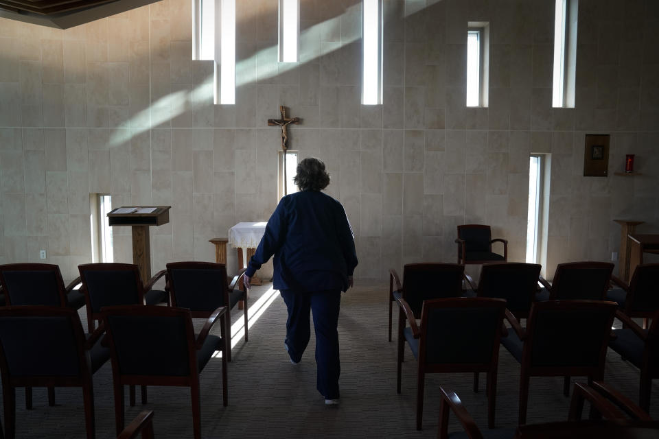 Chaplain Nancy Many visits a chapel after offering communion to a COVID-19 patient at Providence Holy Cross Medical Center in the Mission Hills section of Los Angeles on Friday, Jan. 15, 2021. As families are barred from visiting loved ones to curb the disease's spread, chaplains often are there to act as surrogates, holding the hands of the dying, praying with them and carrying iPads into hospital rooms to provide a real-time connection with grieving families. (AP Photo/Jae C. Hong)