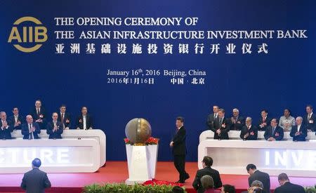 Representatives of the founding nations of the Asian Infrastructure Investment Bank (AIIB) applaud as Chinese President Xi Jinping (C) unveils a sculpture during the opening ceremony of the AIIB in Beijing, China, January 16, 2016. REUTERS/Mark Schiefelbein/Pool