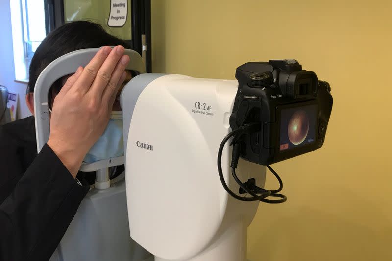 Benny Zee demonstrates retinal eye scanning technology used for early detection of autism in Hong Kong