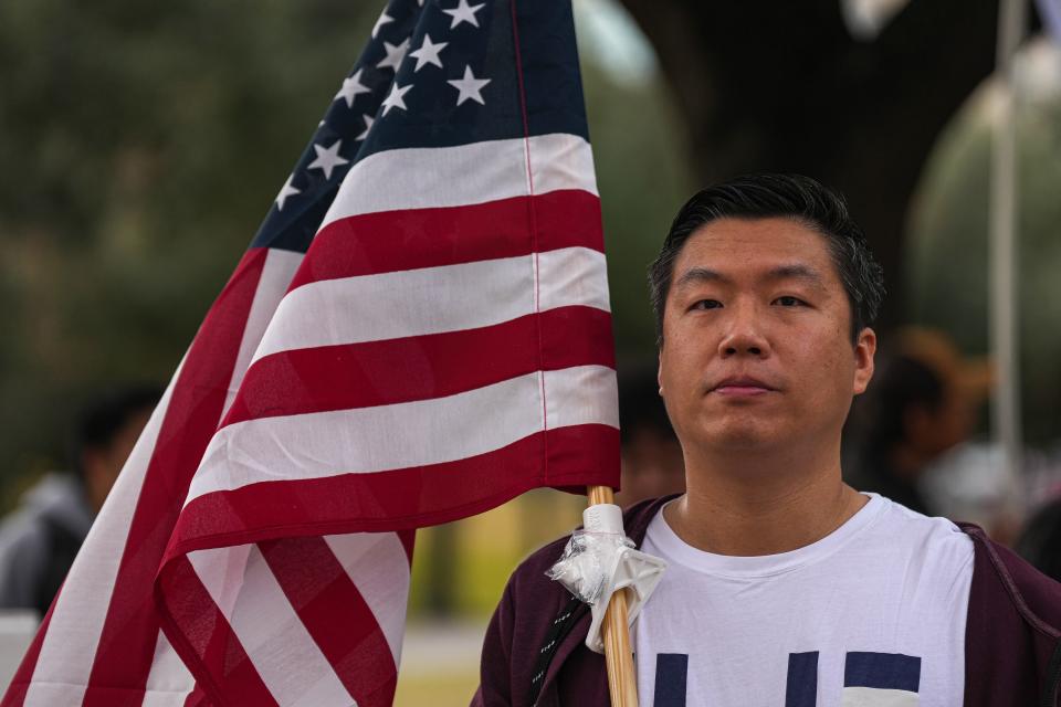 Xiaoan Zhang holds up an American flag at a rally protesting Texas Senate bill 147 at the Texas Capitol on Jan. 29, 2023 in Austin. "I was a green card holder until two days ago. I feel like if they want to fight foreign land ownership, they should ban all foreign ownership. This targets specific countries," Zhang said.