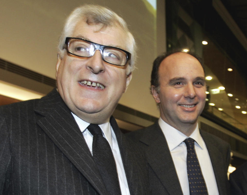 FILE - Prada group president and Ceo Patrizio Bertelli and Luxottica Ceo Andrea Guerra smile during a meeting in Milan, Italy, Nov. 30, 2005. The Prada fashion house began charting a line of succession on its business side, announcing Tuesday, Dec. 6, 2022 that it is tapping a former LVMH executive as its next CEO, while confirming that Miuccia Prada will continue in her creative roles. Andrea Guerra is set to be confirmed by the board next month as the new CEO, succeeding Patrizio Bertelli, who will remain on as chairman. (AP Photo/Luca Bruno, file)