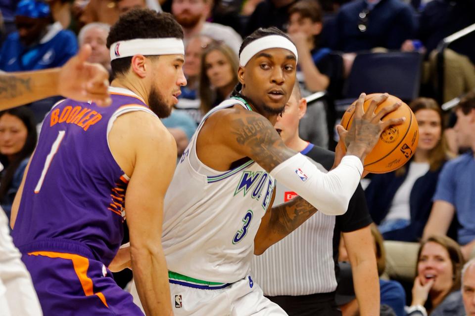 Minnesota Timberwolves forward Jaden McDaniels (3) works around Phoenix Suns guard Devin Booker (1) in the first quarter at Target Center in Minneapolis on April 14, 2024.