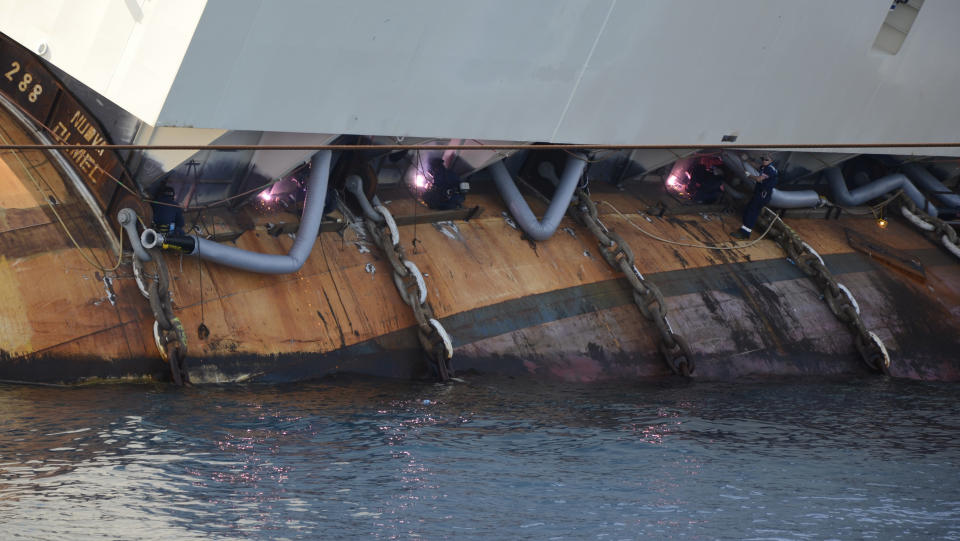 Welders work on the Costa Concordia Ship wreck in the Tuscan Island of Isola del Giglio , Monday, July 15, 2013. Salvage crews are working against time to right and remove the shipwrecked Costa Concordia cruise ship, which is steadily compressing down on itself from sheer weight onto its granite seabed perch off the Tuscan island of Giglio. Salvage master Nick Sloane said Monday that the Concordia has compressed some 3 meters (10 feet) since it came to rest on the rocks Jan. 13, 2012 after ramming a jagged reef during a stunt ordered by the captain that cost the lives of 32 people. (AP Photo/ Michele Barbero)