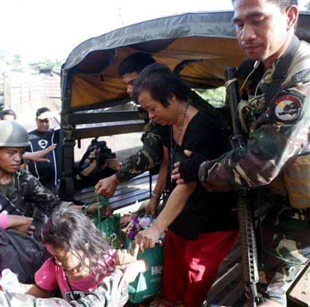 Government soldiers help former hostages of the Muslim rebels of Moro National Liberation Front (MNLF) after they were released from their one-week captivity in Zamboanga city, in southern Philippines September 17, 2013. REUTERS/Erik De Castro