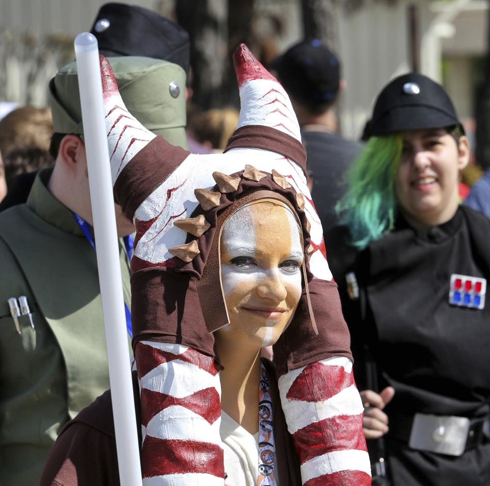 Costumed fans of the Star Wars franchise wait in a massive line outside the Orange County Center, in Orlando, Fla., to attend the 2017 Star Wars Celebration, Thursday, April 13, 2017, marking the 40th anniversary of the original 1977 Star Wars film. Thousands of fans waited for hours in the line, estimated to be more than a mile long. (Joe Burbank/Orlando Sentinel via AP)