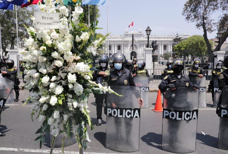 Police officers stand guard outside the government palace as people take to the streets and celebrate after interim President Manuel Merino resigned in a television address, in Lima