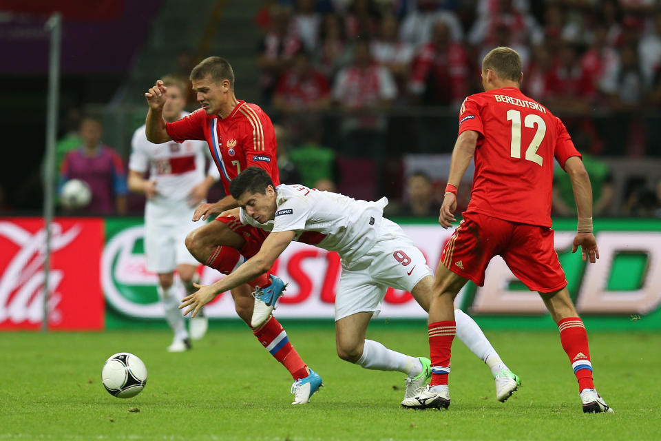 WARSAW, POLAND - JUNE 12: Robert Lewandowski of Poland clashes with Igor Denisov of Russia during the UEFA EURO 2012 group A match between Poland and Russia at The National Stadium on June 12, 2012 in Warsaw, Poland. (Photo by Alex Grimm/Getty Images)