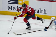 Washington Capitals center Evgeny Kuznetsov (92) shoots the puck past Colorado Avalanche right wing Logan O'Connor (25) during the third period of an NHL hockey game Tuesday, Oct. 19, 2021, in Washington. The Capitals won 6-3. (AP Photo/Alex Brandon)