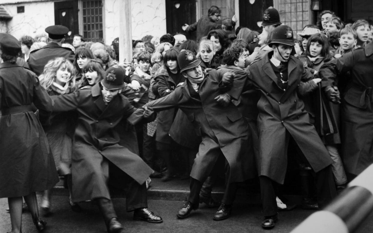 Policemen in London hold back raging Fab Four fans (c. 1960)