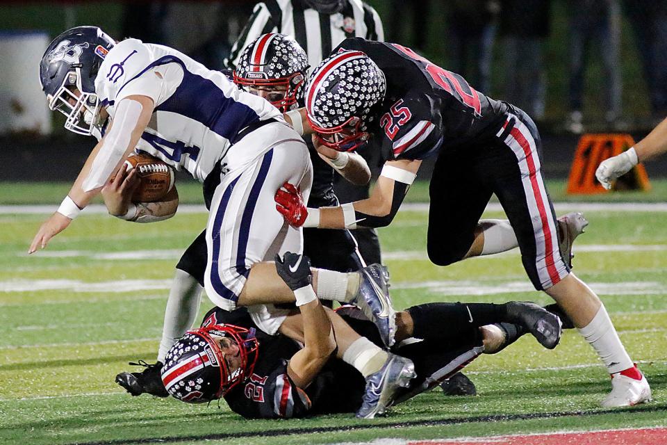 Crestview's Adison Reymer (21), Owen Barker (25) and Connor Morse (3) bring down Carey's Jordan Vallejo (24) during their OHSAA Division VI regional semifinal football game on Saturday, Nov. 13, 2021 at Marion Harding High School.