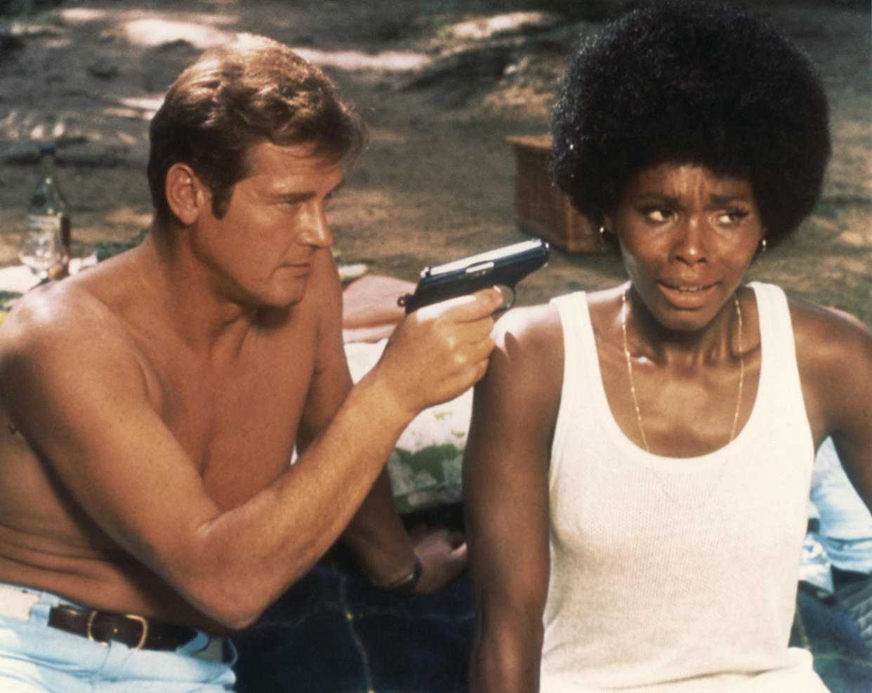 Actor Roger Moore and actress Gloria Hendry on the set of 