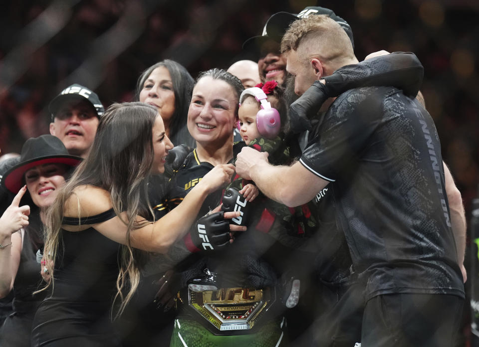 Raquel Pennington, center, celebrates after defeating Mayra Bueno Silva in a women's bantamweight title bout during the UFC 297 mixed martial arts event in Toronto on Saturday, Jan. 20, 2024. (Nathan Denette/The Canadian Press via AP)