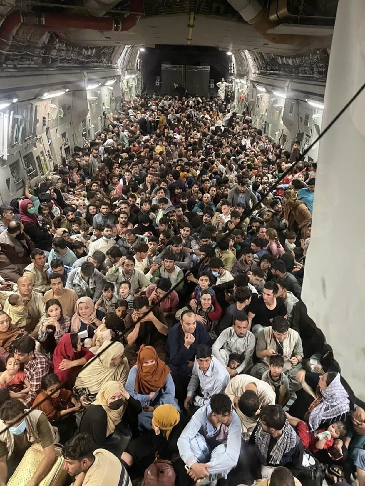 <span class="caption">Hundreds of Afghan citizens, fleeing their home country, await takeoff after packing inside a U.S. Air Force C-17 transport at Hamid Karzai International Airport in Afghanistan. </span> <span class="attribution"><a class="link " href="https://newsroom.ap.org/detail/APTOPIXAfghanistan/883d778492c94ae098a479e8a91f3253/photo?Query=(renditions.phototype:vertical%20OR%20renditions.phototype:horizontal)%20AND%20%20(Afghanistan%20Kabul%20Airport)%20&mediaType=photo&sortBy=&dateRange=&totalCount=128&currentItemNo=13" rel="nofollow noopener" target="_blank" data-ylk="slk:AP Photo/Capt. Chris Herbert/U.S. Air Force;elm:context_link;itc:0;sec:content-canvas">AP Photo/Capt. Chris Herbert/U.S. Air Force</a></span>