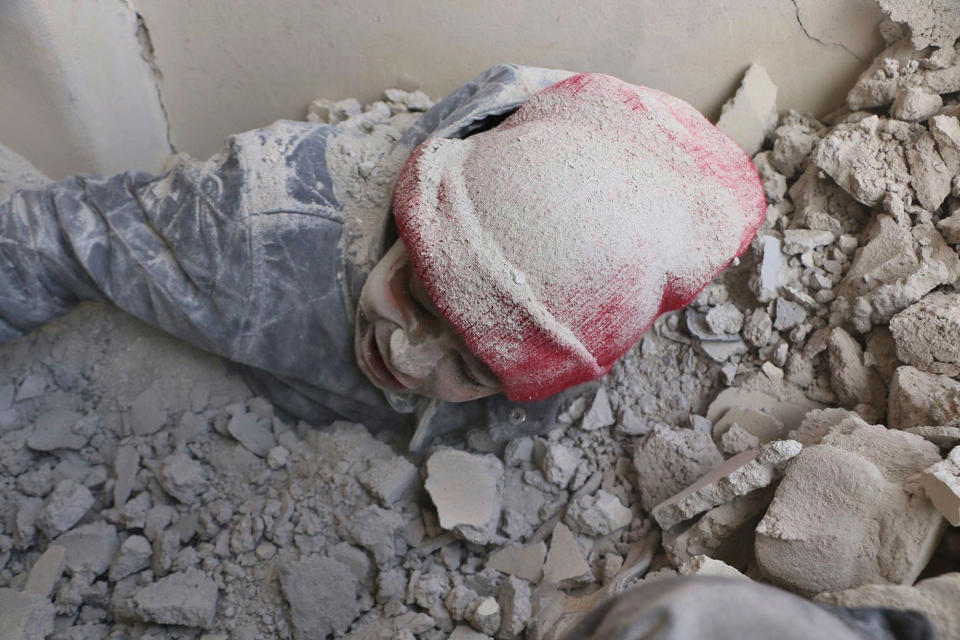 <p>A child is partly buried in rubble after airstrikes hit a rebel-held suburb near Damascus, Syria, Monday, Feb. 5, 2018. (Photo: Syrian Civil Defense White Helmets via AP) </p>