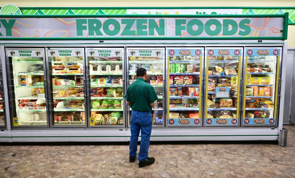 A man looks at frozen foods for sale at a Dollar Store.