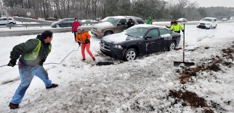 Priscilla Hernandez (pink coat) watches as a wrecker crew pulls her vehicle from the median on Hwy 70 near I-540 Thursday Feb. 13, 2014. Hernandez was ecstatic when the crew pulled her car out of the ditch without causing any damage. Chuck Liddy/cliddy@newsobserver.com