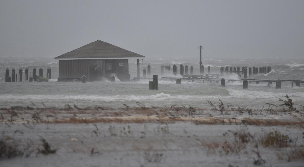 The late afternoon high tide washes over the Hyannis Port Yacht Club pier and floods Eugenia Fortes Beach.