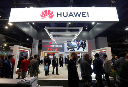 FILE PHOTO: Attendees pass by a Huawei booth during the 2019 CES in Las Vegas, Nevada, U.S. January 9, 2019. REUTERS/Steve Marcus/File Photo
