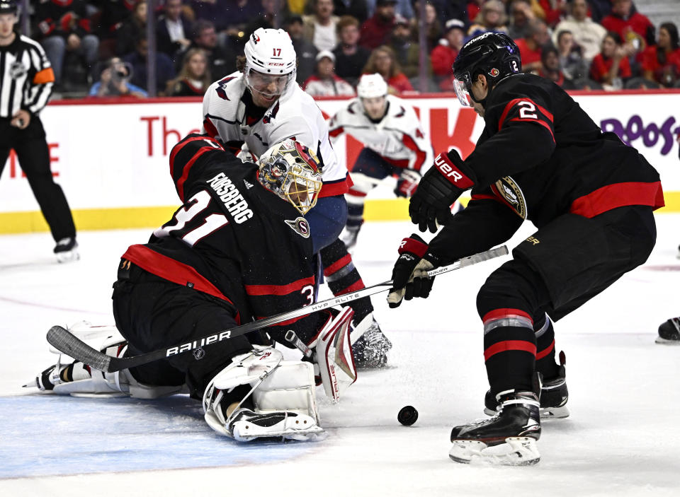 Ottawa Senators goaltender Anton Forsberg (31) and defenseman Artem Zub (2) defend against Washington Capitals center Dylan Strome (17) during the second period of an NHL hockey game in Ottawa, Ontario on Wednesday, Oct. 18, 2023. (Justin Tang/The Canadian Press via AP)