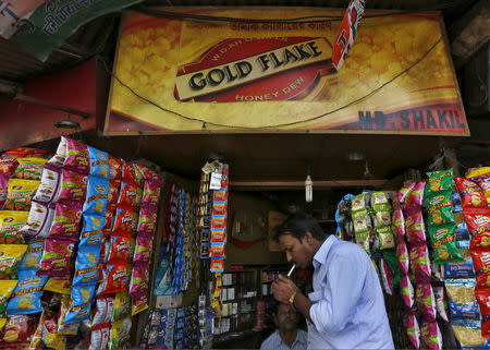 A man lights a cigarette in front of a kiosk in Kolkata, India, April 7, 2016. REUTERS/Rupak De Chowdhuri