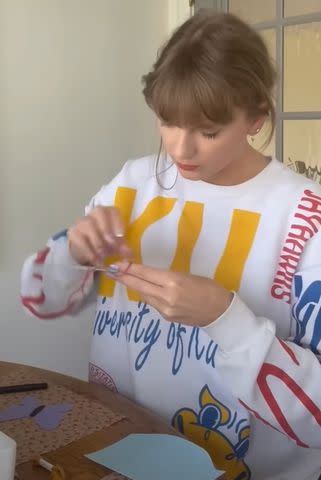 <p>YouTube/Taylor Swift</p> Taylor Swift rocks a University of Kansas sweater in her latest YouTube video
