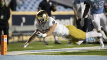 Notre Dame's George Takacs (85) gets past North Carolina's Tyrone Hopper (42) picking up 13 yards on a pass completion from quarterback Ian Book (12) and dive toward the goal line, but is stopped short during the fourth quarter of an NCAA college football game Friday, Nov. 27, 2020, in Chapel Hill, N.C. (Robert Willett/The News & Observer via AP, Pool)