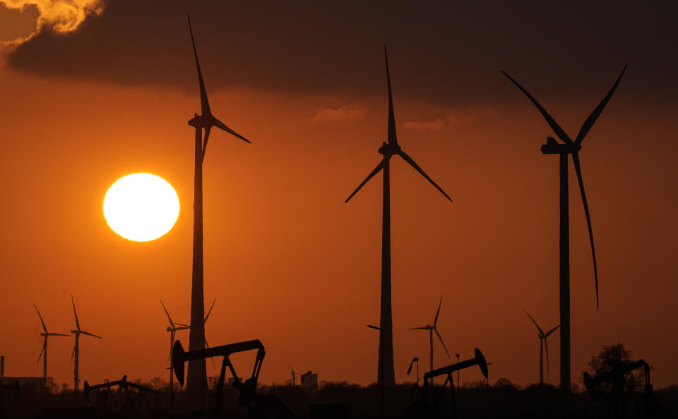 FILE - Wind turbines produce power during sundown in Emlichheim, Germany, Friday, March 18, 2022. A new study released on Wednesday, April 13 finds that if the nations of the world live up to their promises, future climate climate change can be limited to the weaker of two international goals. According to a study, the world is potentially on track to keep global warming at or a shade below 2 degrees Celsius (3.6 degrees Fahrenheit) hotter than pre-industrial times, a goal that once seemed out of reach. (AP Photo/Martin Meissner, File)