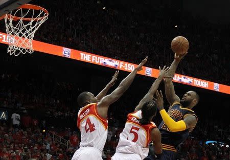 May 22, 2015; Atlanta, GA, USA; Cleveland Cavaliers forward LeBron James (23) shoots against Atlanta Hawks forward DeMarre Carroll (5) and forward Paul Millsap (4) during the second quarter in game two of the Eastern Conference Finals of the NBA Playoffs at Philips Arena. Brett Davis-USA TODAY Sports