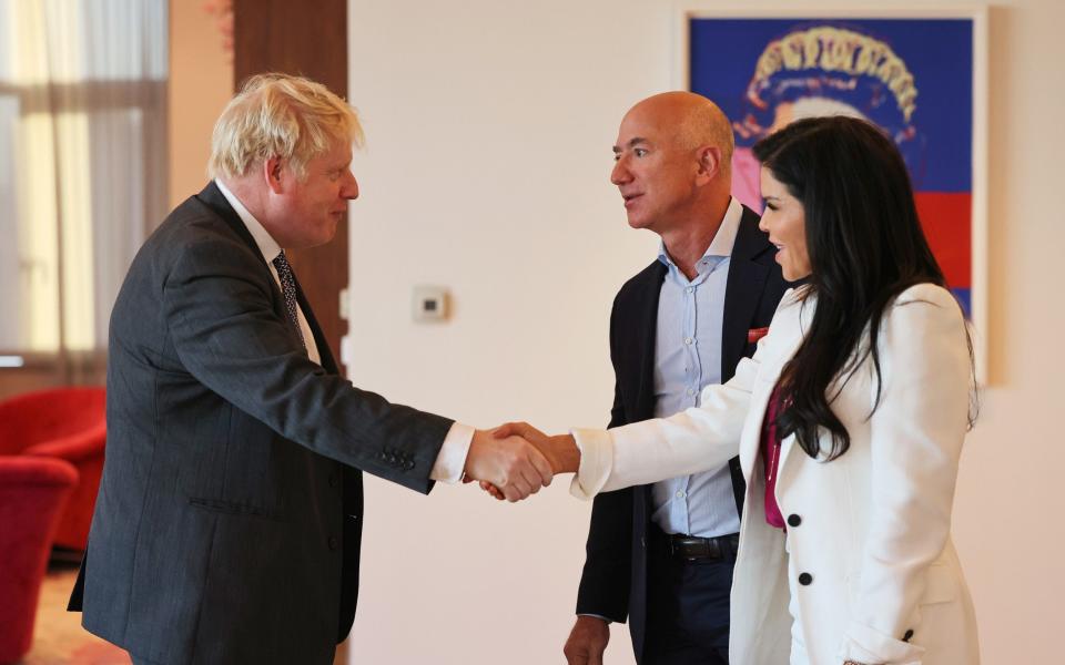 British Prime Minister Boris Johnson greets Amazon founder Jeff Bezos and his partner, news anchor Lauren Sanchez  - Michael M. Santiago /Getty Images North America 