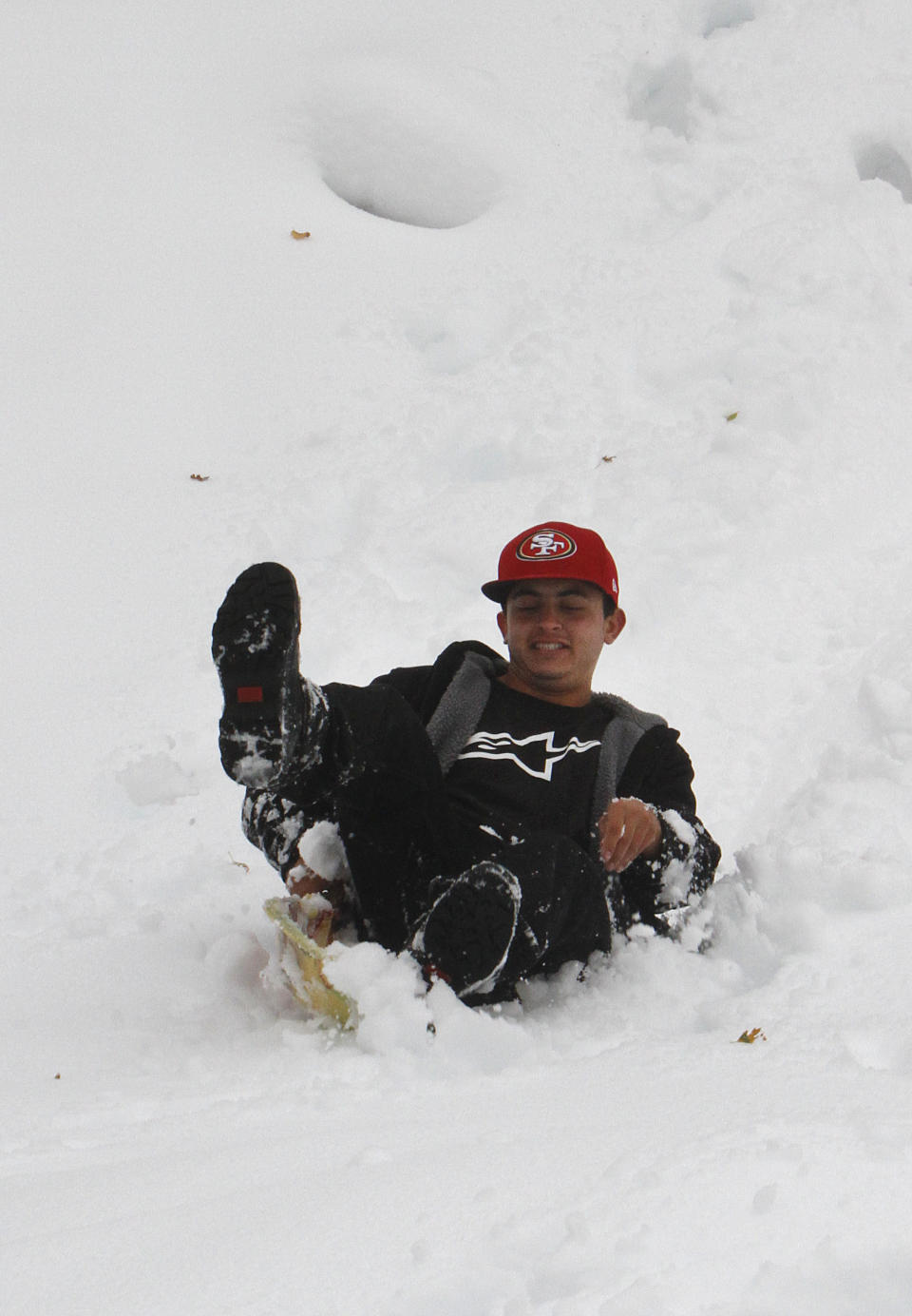 Chris Gilbert sleds down a slop  on freshly fallen snow near Blue Canyon, Calif., Monday, Oct. 22, 2012. The first storm of the season swept through Northern California bringing rain to the lower elevations and snow in the mountains. (AP Photo/Rich Pedroncelli)