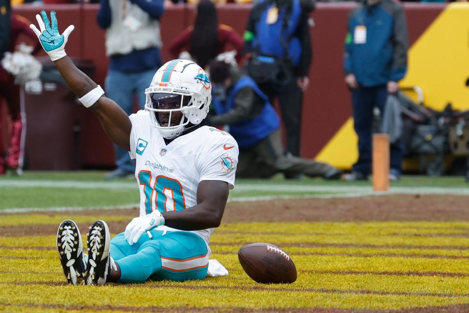 Dec 3, 2023; Landover, Maryland, USA; Miami Dolphins wide receiver Tyreek Hill (10) celebrates in the end zone after catching a touchdown pass against the Washington Commanders during the first quarter at FedExField. Mandatory Credit: Geoff Burke-USA TODAY Sports