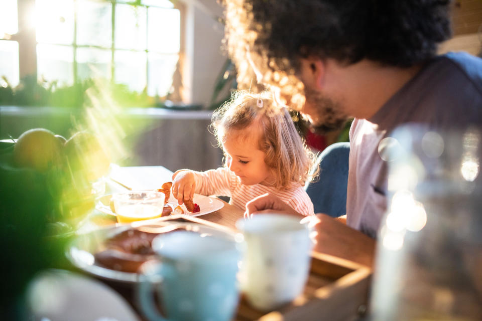 Dad and daughter eating breakfast together. (Getty Images)