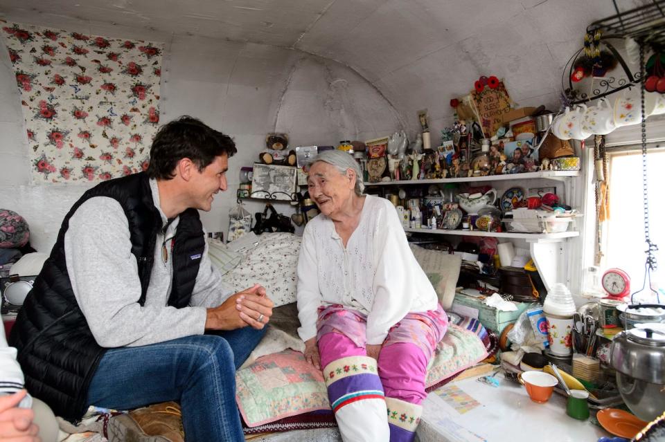 Prime Minister Justin Trudeau talks with Inuit elder Qaapik Attagutsiak, 99, in her tiny home during a visit to Arctic Bay, Nvt., on Thursday, Aug. 1, 2019.   