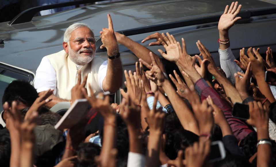 FILE - In this April 30, 2014 file photo, India's main opposition Bharatiya Janata Party’s prime ministerial candidate Narendra Modi displays his inked finger to supporters after casting his vote in Ahmadabad, India. Indian elections results due Friday, May 16, 2014, provide a chance to repair relations with the U.S. that were strained by the arrest of an Indian diplomat in New York. But there's a big catch: Washington's uneasy relationship with the man expected to become India's next prime minister. Hindu nationalist leader Modi was in 2005 denied a U.S. visa for alleged complicity in religious riots in 2002 that killed more than 1,000 Muslims. Exit polls show his Bharatiya Janata Party and its allies with a large lead over the ruling Congress party and its allies after voting ended Monday, May 12. (AP Photo/Ajit Solanki, File)