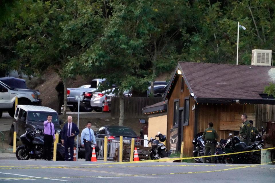 Detectives look at motorcycles that remain parked at Cook's Corner on Thursday, Aug. 24, 2023, the day after a mass shooting in Trabuco Canyon. Authorities say the retired Ventura police officer who opened fire at the popular Orange County bar entered and first shot his estranged wife and her dinner companion before firing at random.