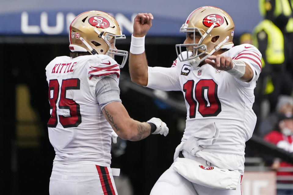 San Francisco 49ers tight end George Kittle (85) celebrates with quarterback Jimmy Garoppolo (10) after scoring a touchdown against the Seattle Seahawks during the first half of an NFL football game, Sunday, Dec. 5, 2021, in Seattle. (AP Photo/Elaine Thompson)