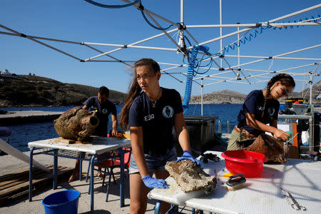 Students of the Department of Conservation of Antiquities and Works of Art Giorgos Agavanakis, 24, Helen Margarita Bardas, 25, and Eirini Mitsi, 23, work on amphorae retrieved from shipwreck sites on the island of Fournoi, Greece, September 20, 2018. Picture taken September 20, 2018. REUTERS/Alkis Konstantinidis