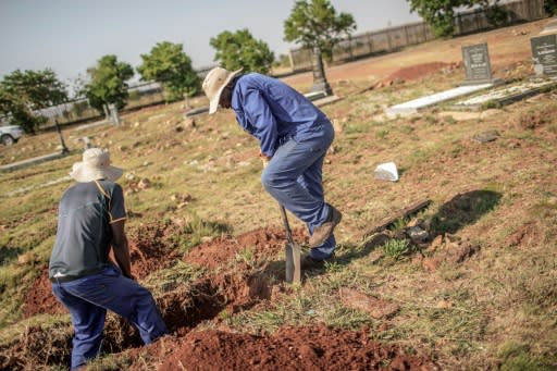 Workers dig a grave at a cemetery