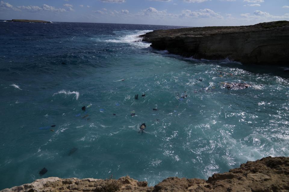 Cadávares de migrantes flotan entre escombros después de que el velero que los transportaba se estrellara contra las rocas y se hundiera frente a la isla de Kythira, en el sur de Grecia, el 6 de octubre de 2022. (AP Foto/Thanassis Stavrakis)