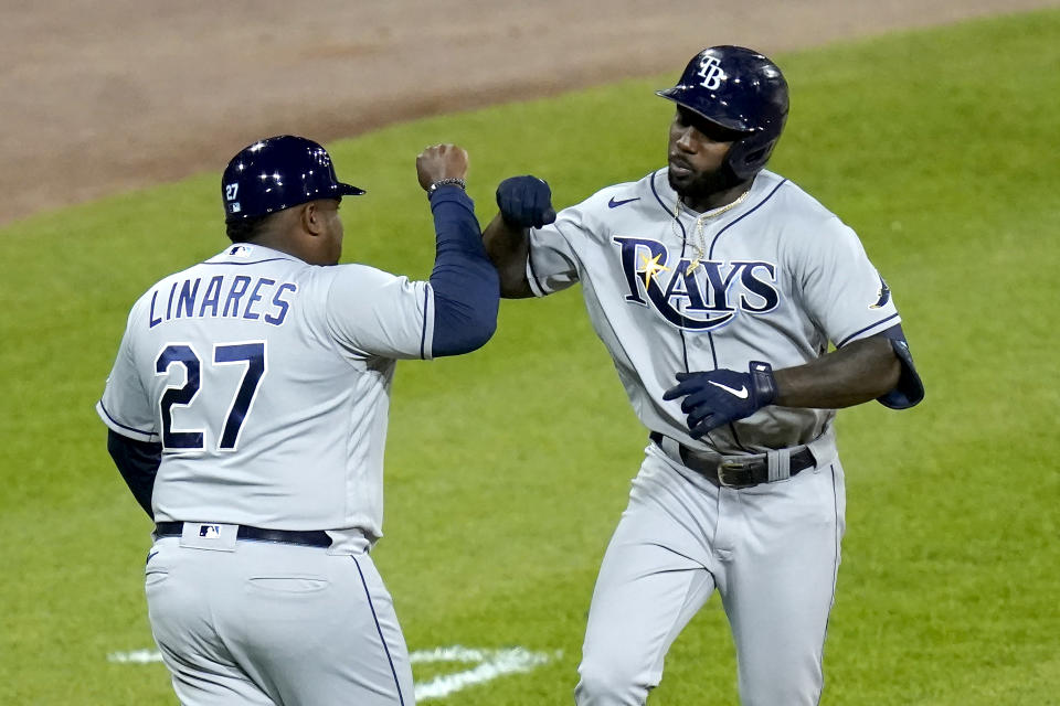 Tampa Bay Rays' Randy Arozarena, right, celebrates his home run off Chicago White Sox relief pitcher Garrett Crochet with third base coach Rodney Linares during the eighth inning of a baseball game Monday, June 14, 2021, in Chicago. (AP Photo/Charles Rex Arbogast)