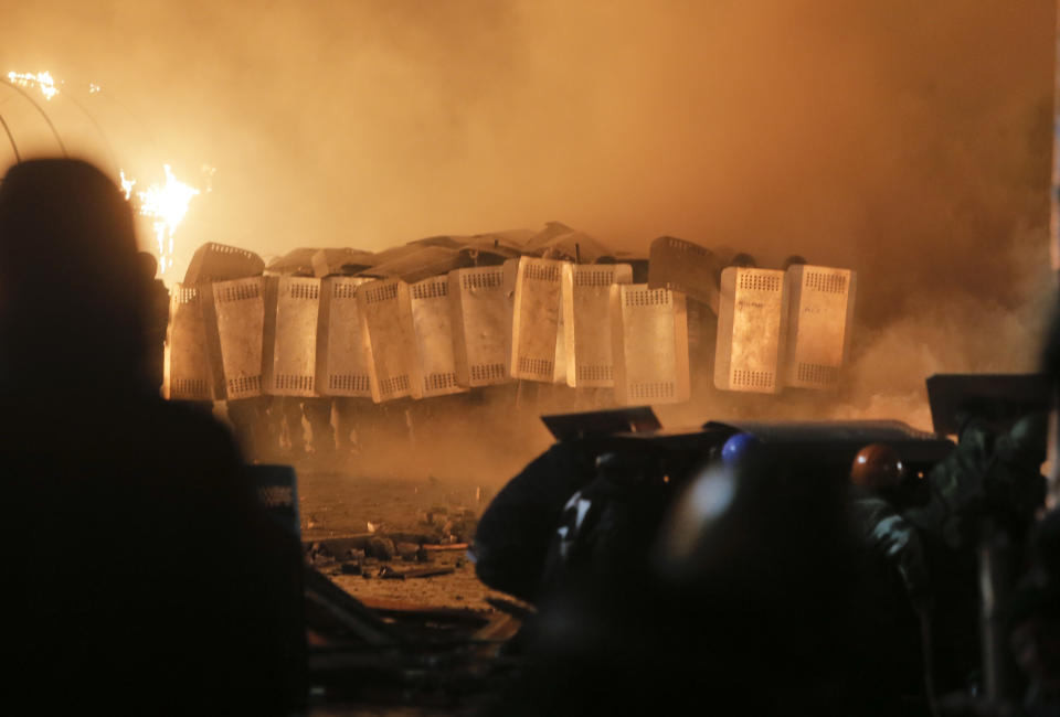 Riot police storm Kiev's Independence Square, the epicenter of the country's current unrest, Kiev, Ukraine, Tuesday, Feb. 18, 2014. Thousands of police armed with stun grenades and water cannons attacked the large opposition camp in Ukraine's capital on Tuesday that has been the center of nearly three months of anti-government protests after at least nine people were killed in street clashes. (AP Photo/Efrem Lukatsky)