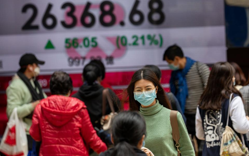Pedestrians in Hong Kong attempt to protect themselves with face masks. Many global experts say it may already be too late to stop the spread of coronavirus - REX
