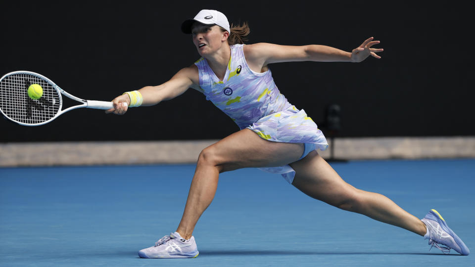 Iga Swiatek of Poland plays a forehand return to Kaia Kanepi of Estonia during their quarterfinal match at the Australian Open tennis championships in Melbourne, Australia, Wednesday, Jan. 26, 2022. (AP Photo/Tertius Pickard)